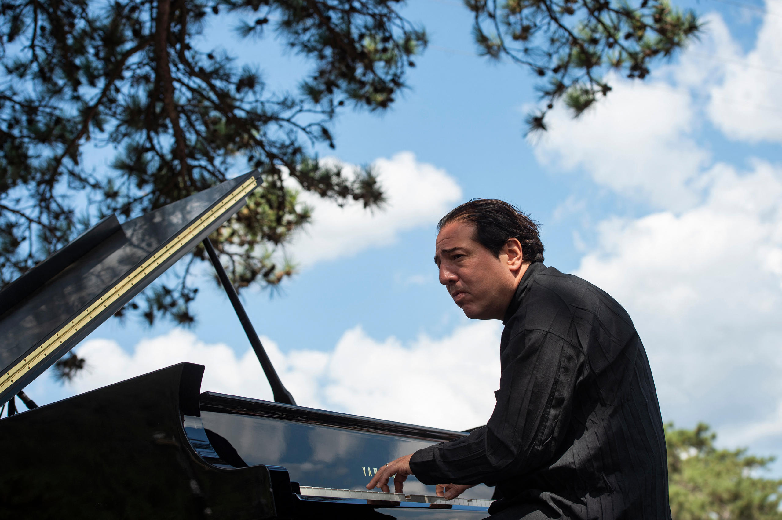 Der Türkische Pianist Fazil Say spielt unter einem Baum Klavier