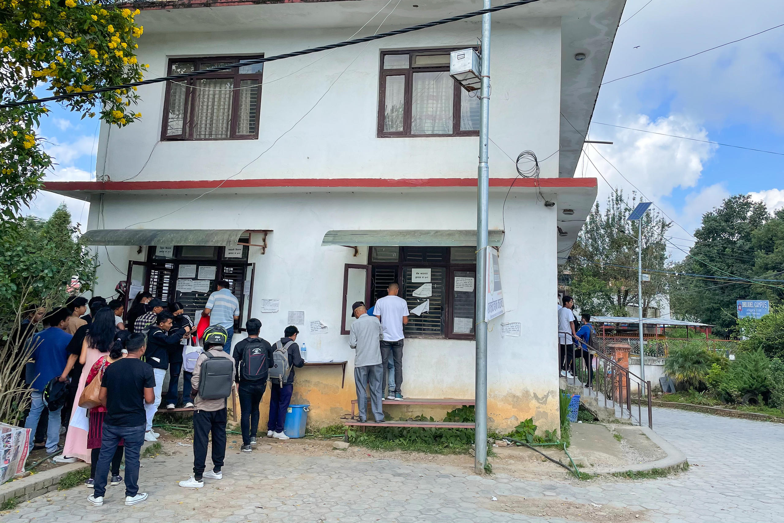 File pour l obtention d un passeport devant une maison au Népal
