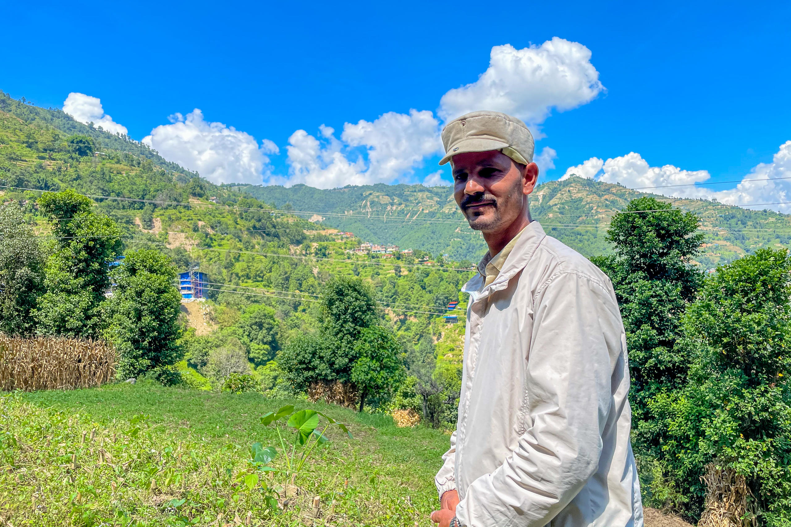 Binod Ghorsaine posiert draussen für die Kamera, im Hintergrund die Berge