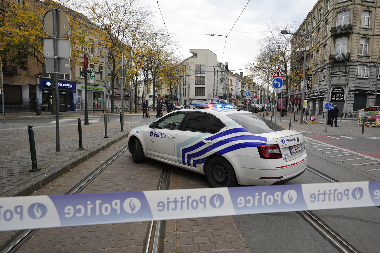 Un auto della polizia in primo piano e dietro il teatro dell attentato.