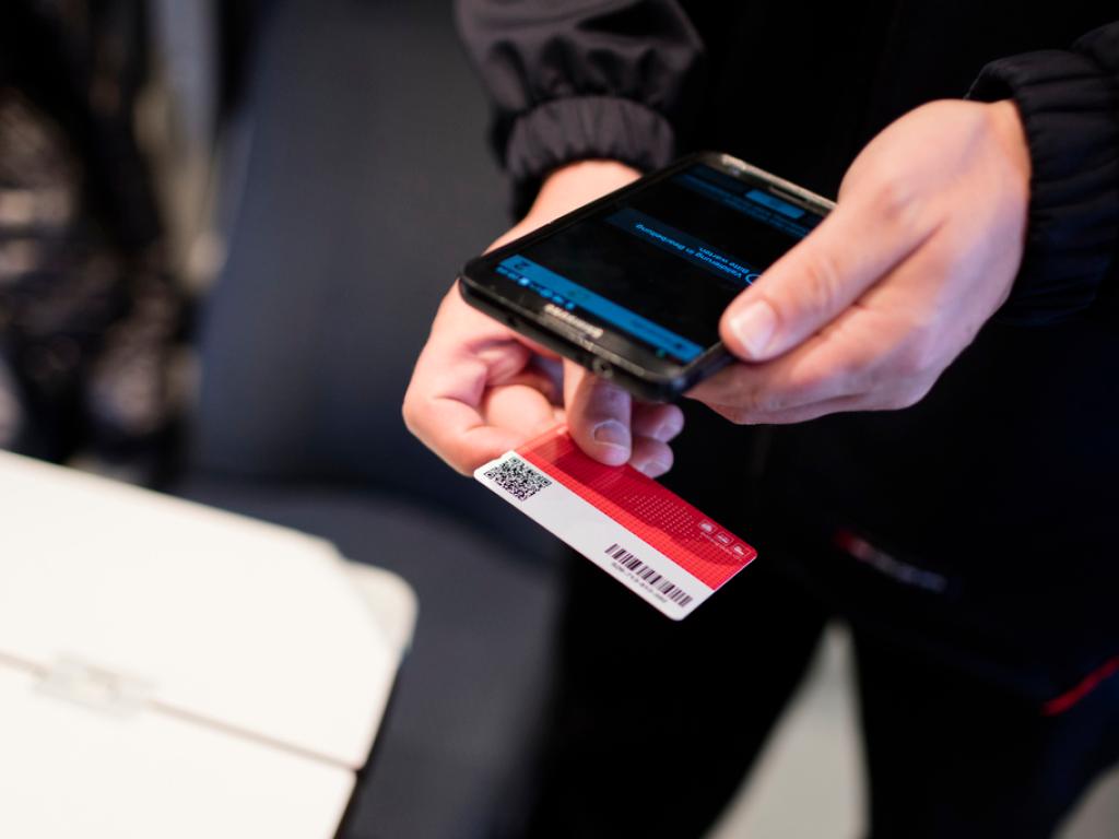 Kondukteur in einem Zug, der einen Swiss Pass kontrolliert