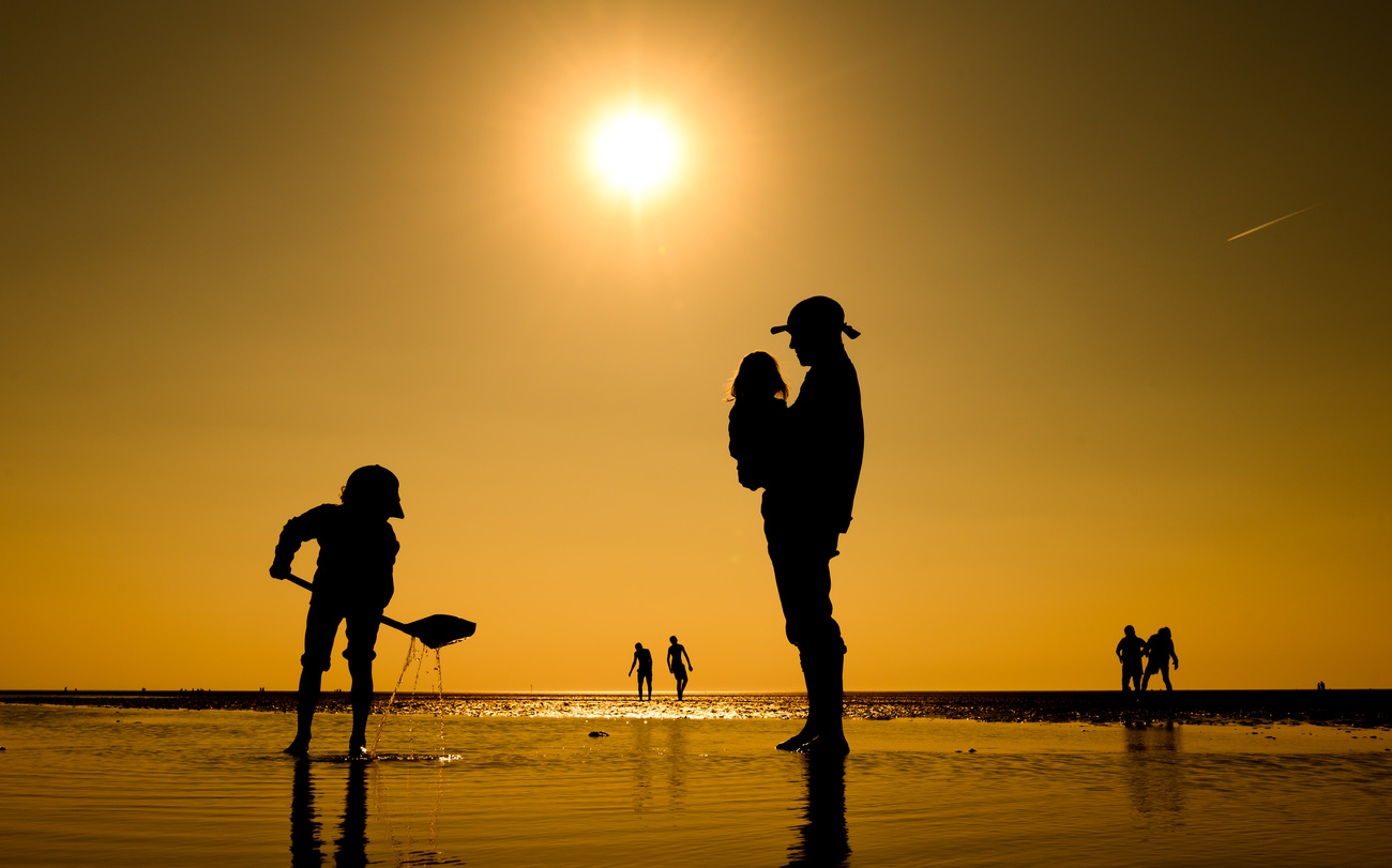 Vater am Strand mit Kindern