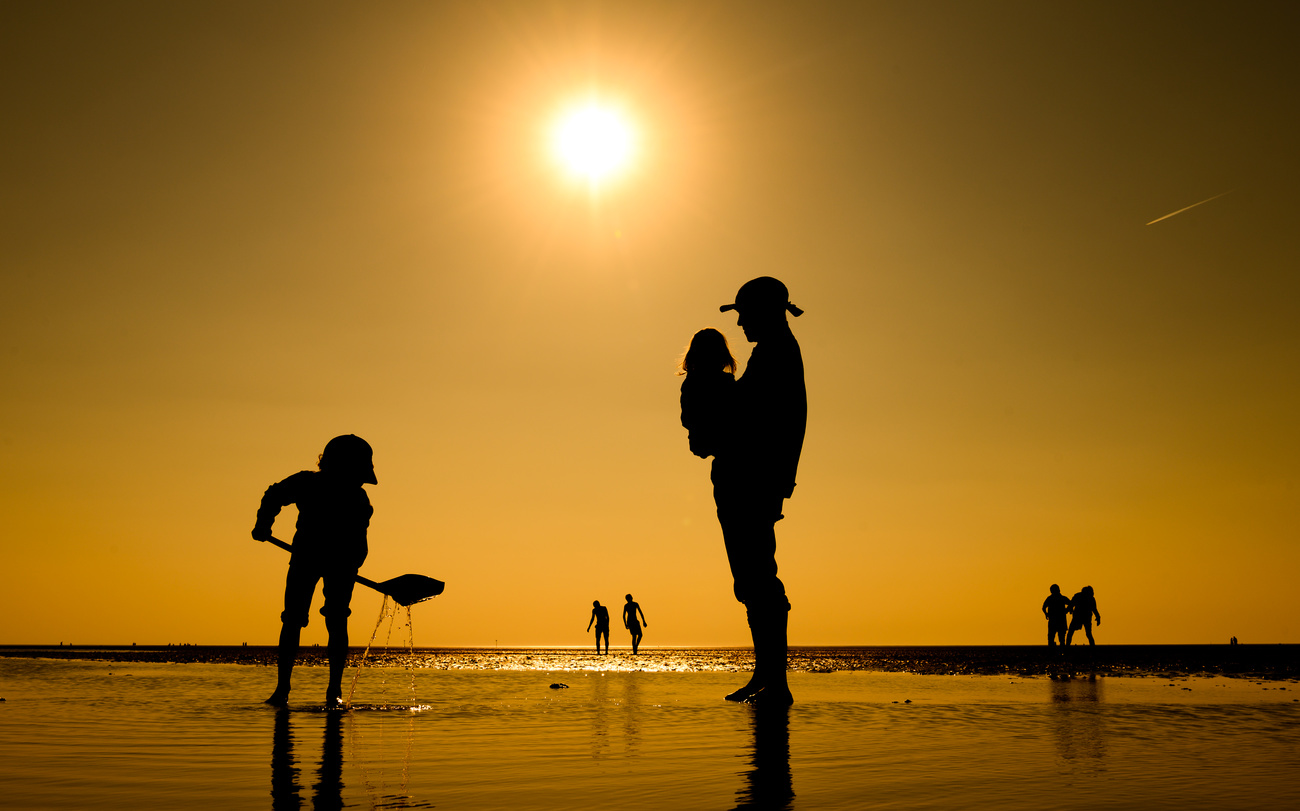 Un père sur un plage avec ses enfants