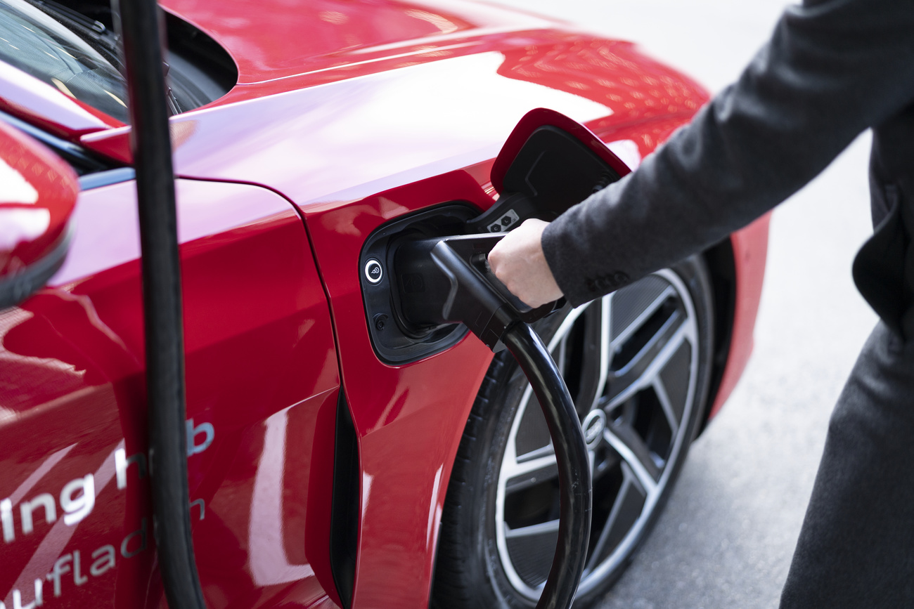 persona fa il pieno di elettricità alla sua auto