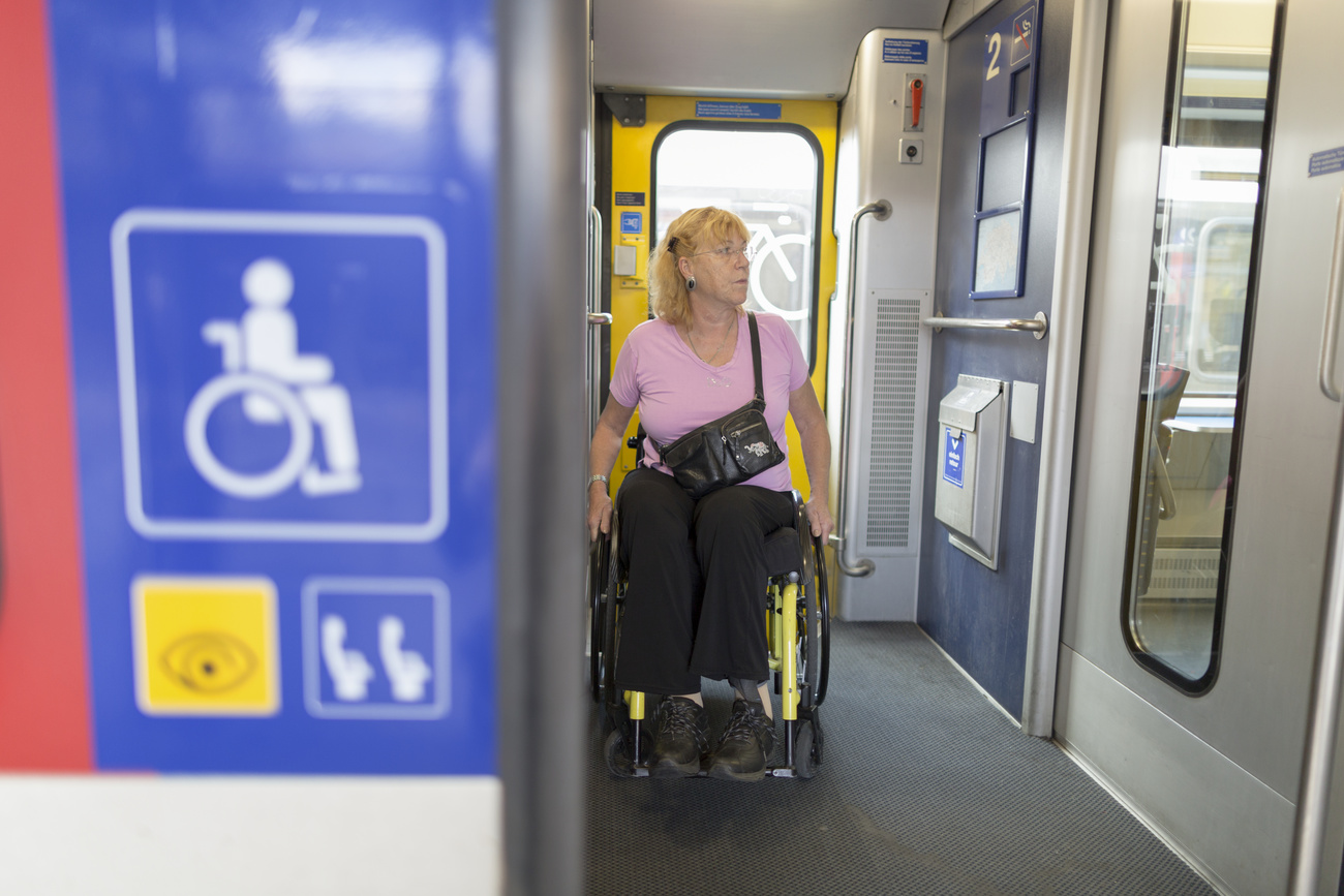 Una donna su una carrozzella a bordo di un treno.
