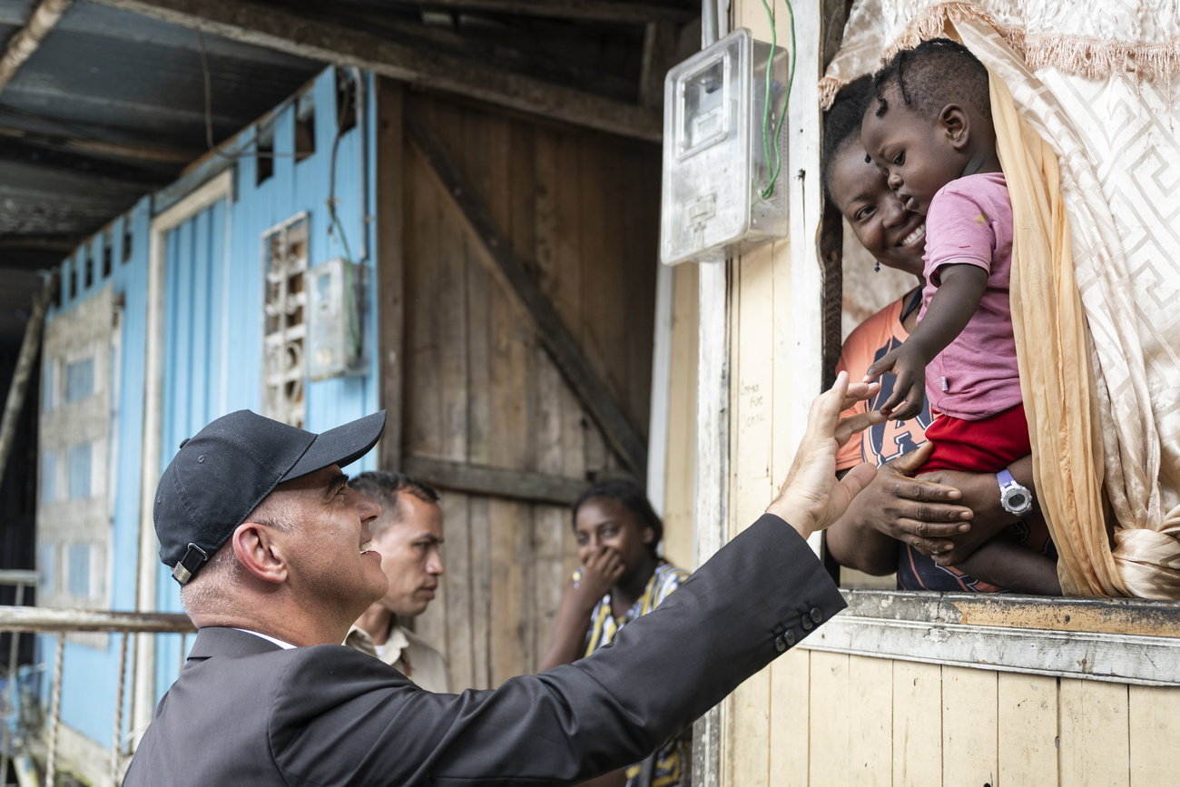 Alain Berset shaking the hand of a young child and laughing