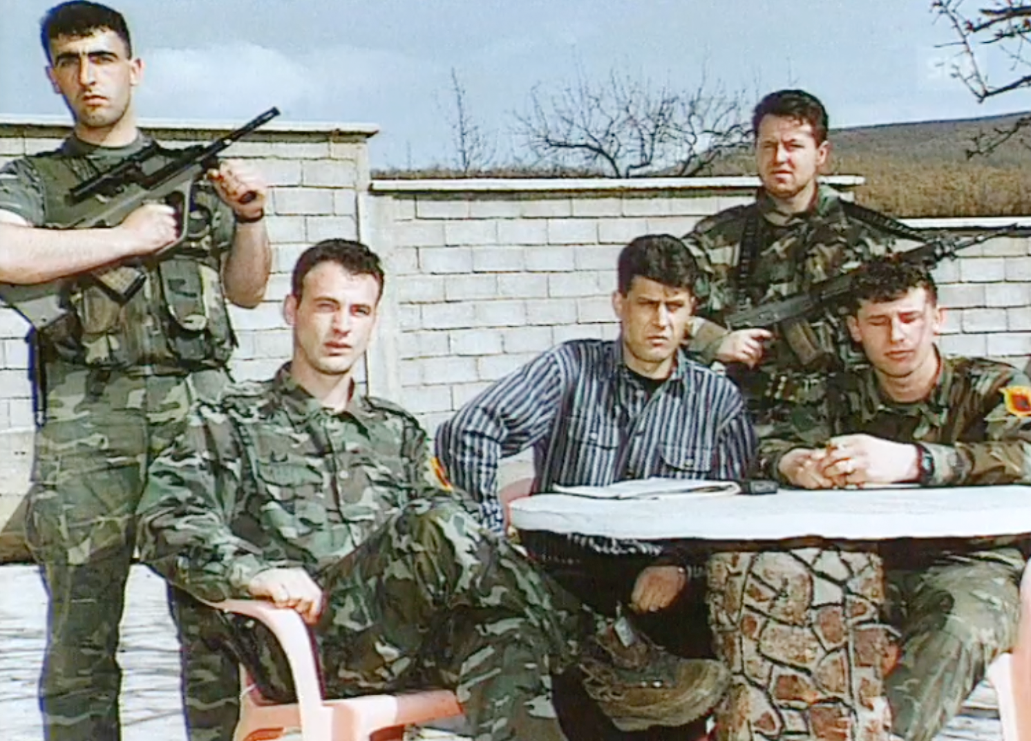 Foto de 4 soldados y Thaçi en medio vestido de civil