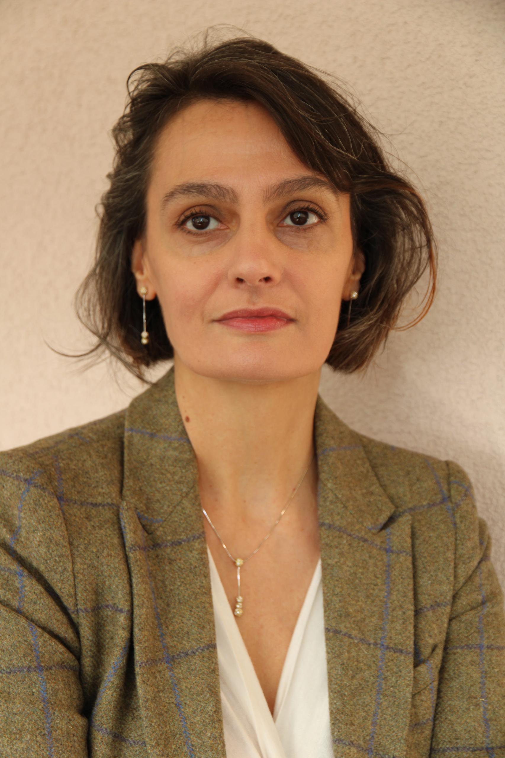 Immagine di una donna che guarda nella fotocamera con i capelli corti e la giacca verde