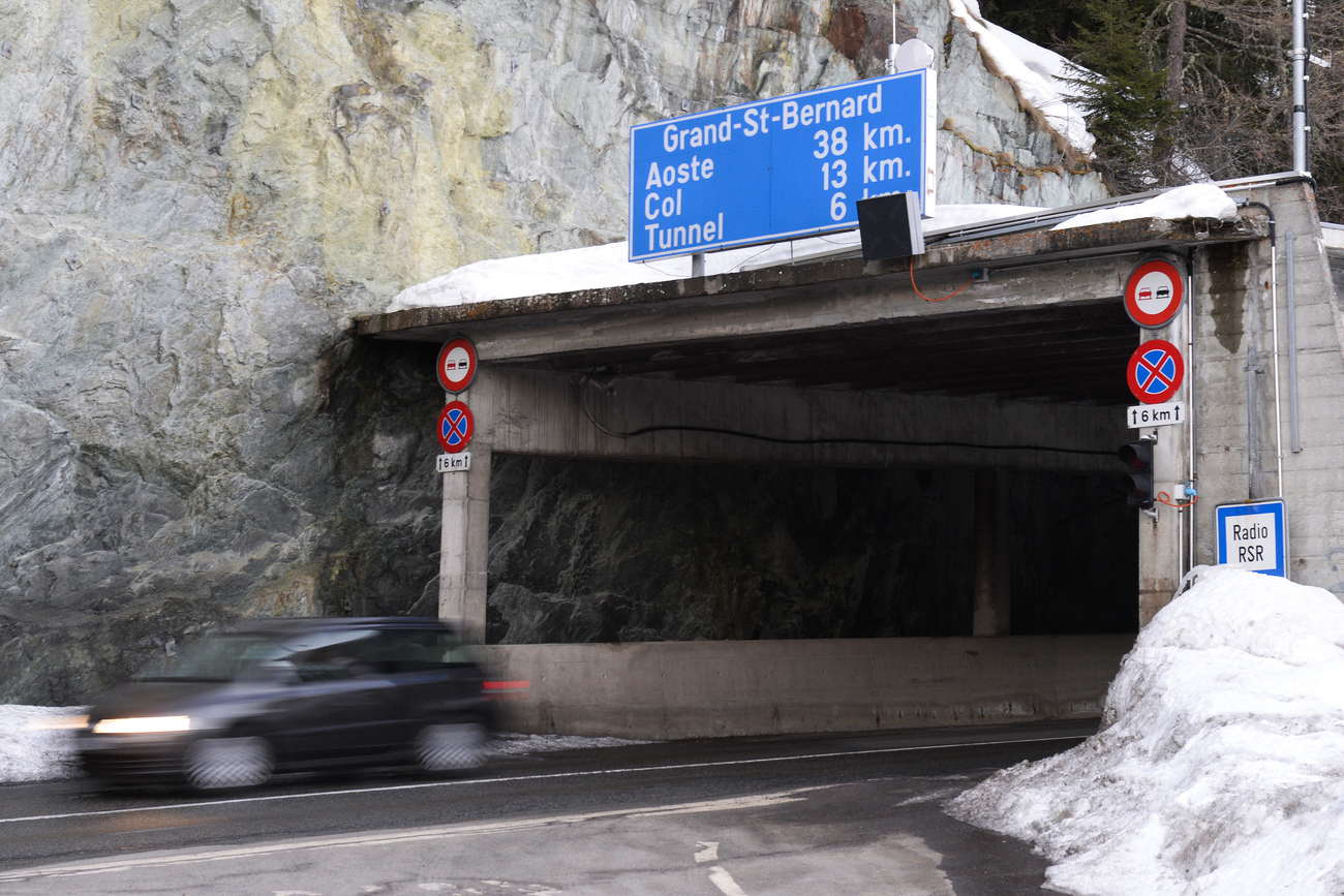 Tunneleinfahrt, ein Schild nennt Tunnellänge und die Distanz zum Aostatal in Italien