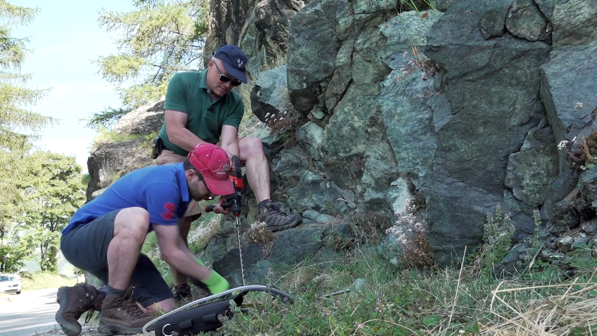 dos personas buscando hidrógeno en una montaña rocosa al sur de Suiza