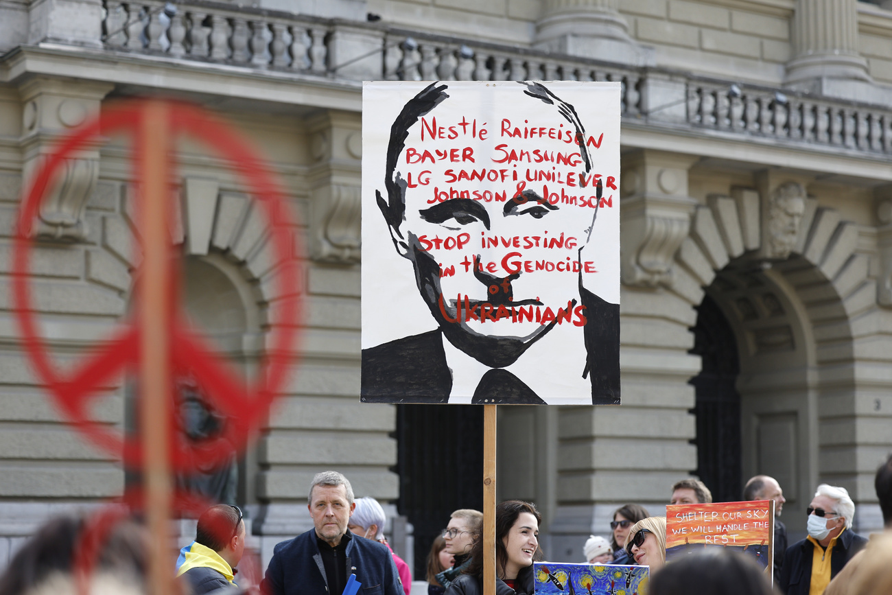 Manifestantes contra la guerra sostienen una pancarta con los nombres de Nestlé y otras empresas