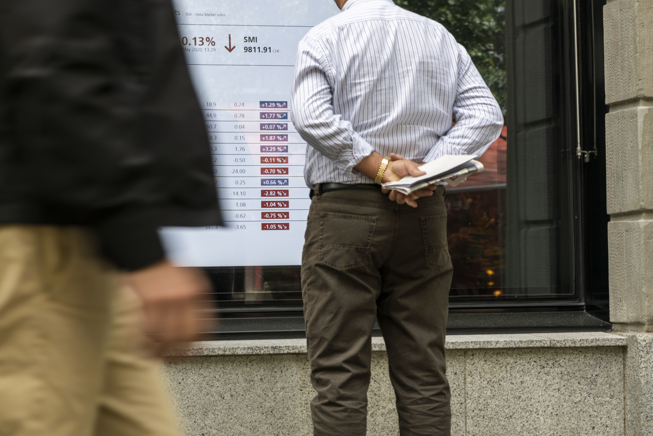 A man follows stock market numbers in window of a UBS bank branch in Zurich