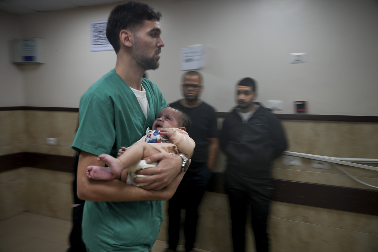 رضيع فلسطيني أُصيب في القصف الإسرائيلي على قطاع غزة، يُنقل إلى مستشفى دير البلح يوم الثلاثاء.