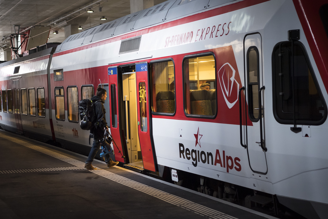 Passenger with skis boarding a RegioAlps train in Switzerland