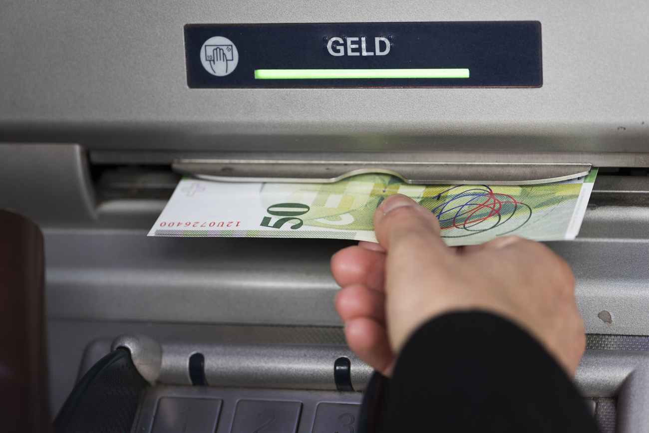 Person withdrawing cash from ATM