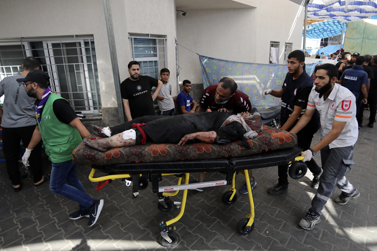 Helfer, die auf einer mobilen Bahre eine verletzte Frau in ein Spital im Gazastreifen bringen