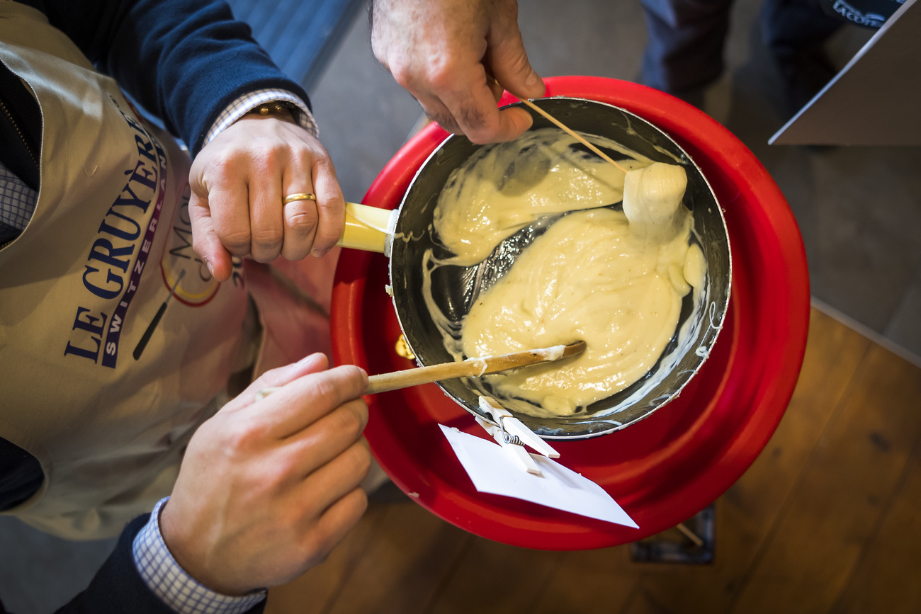 Hände, die in einem Fondue rühren