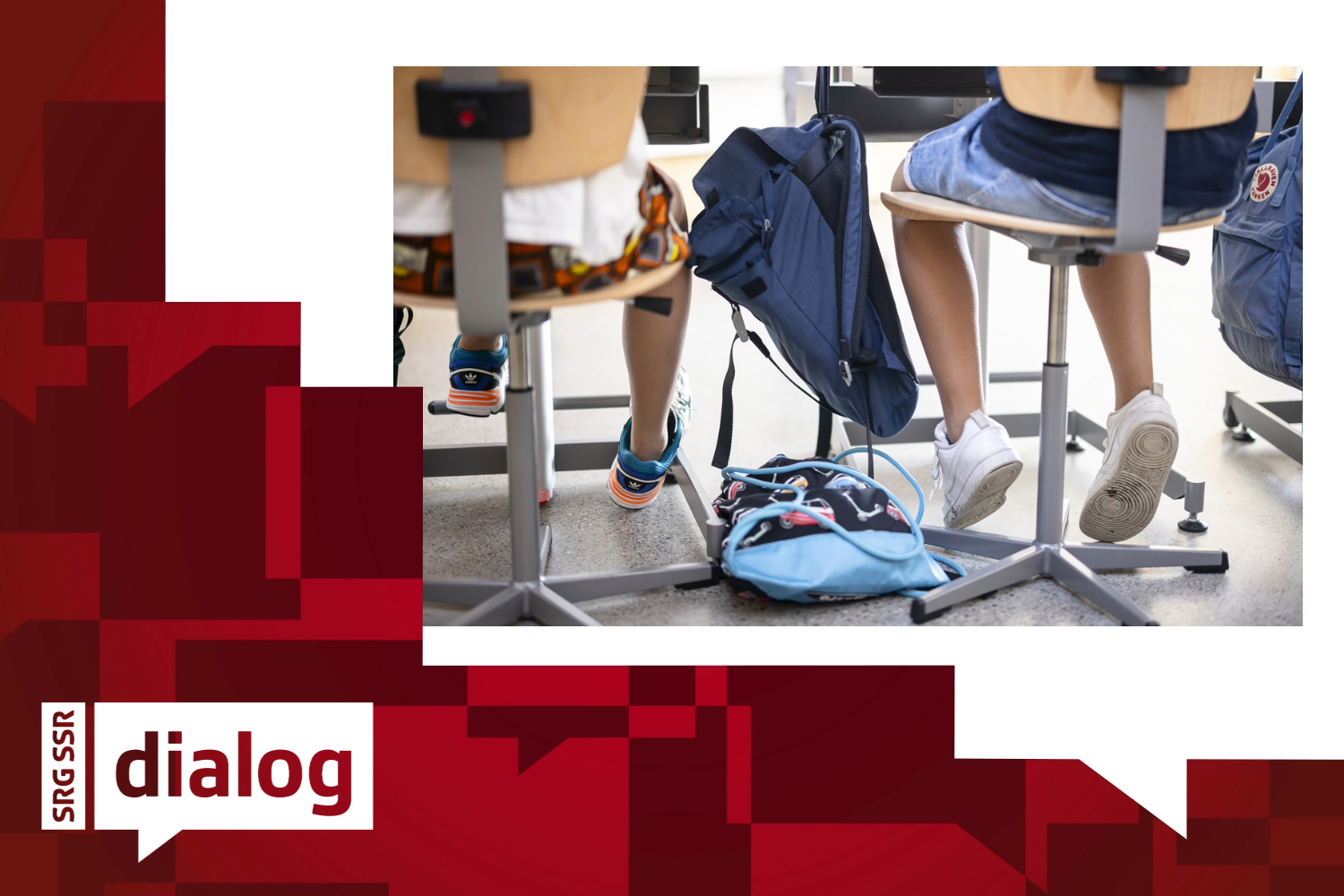Schülerinnen und Schüler sitzen in der SChule and ihren Tischen