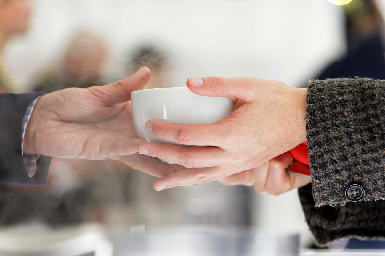 Picture of a person handing a bowl of food to another