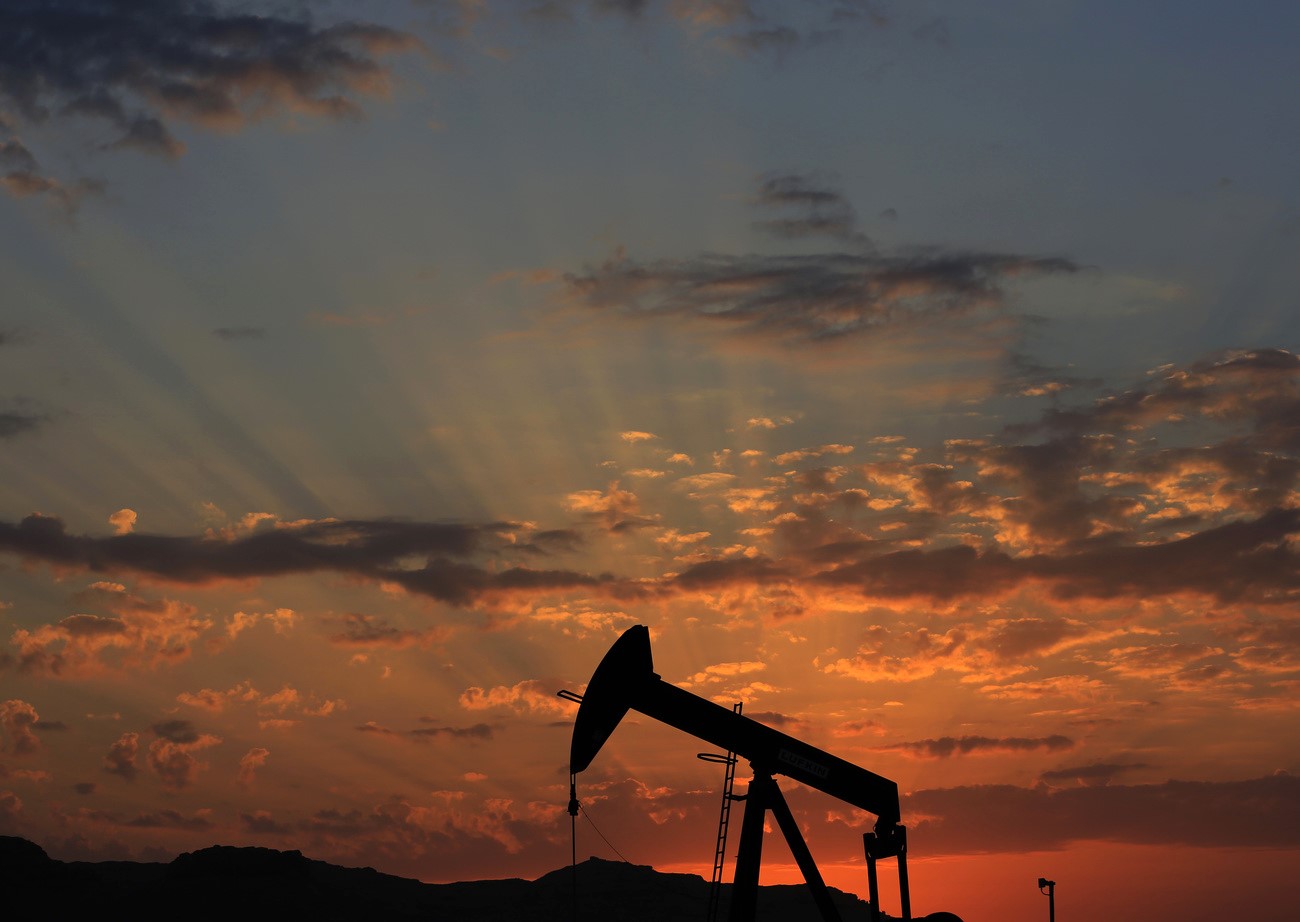 una bomba de petróleo con un cielo de atardecer de fondo