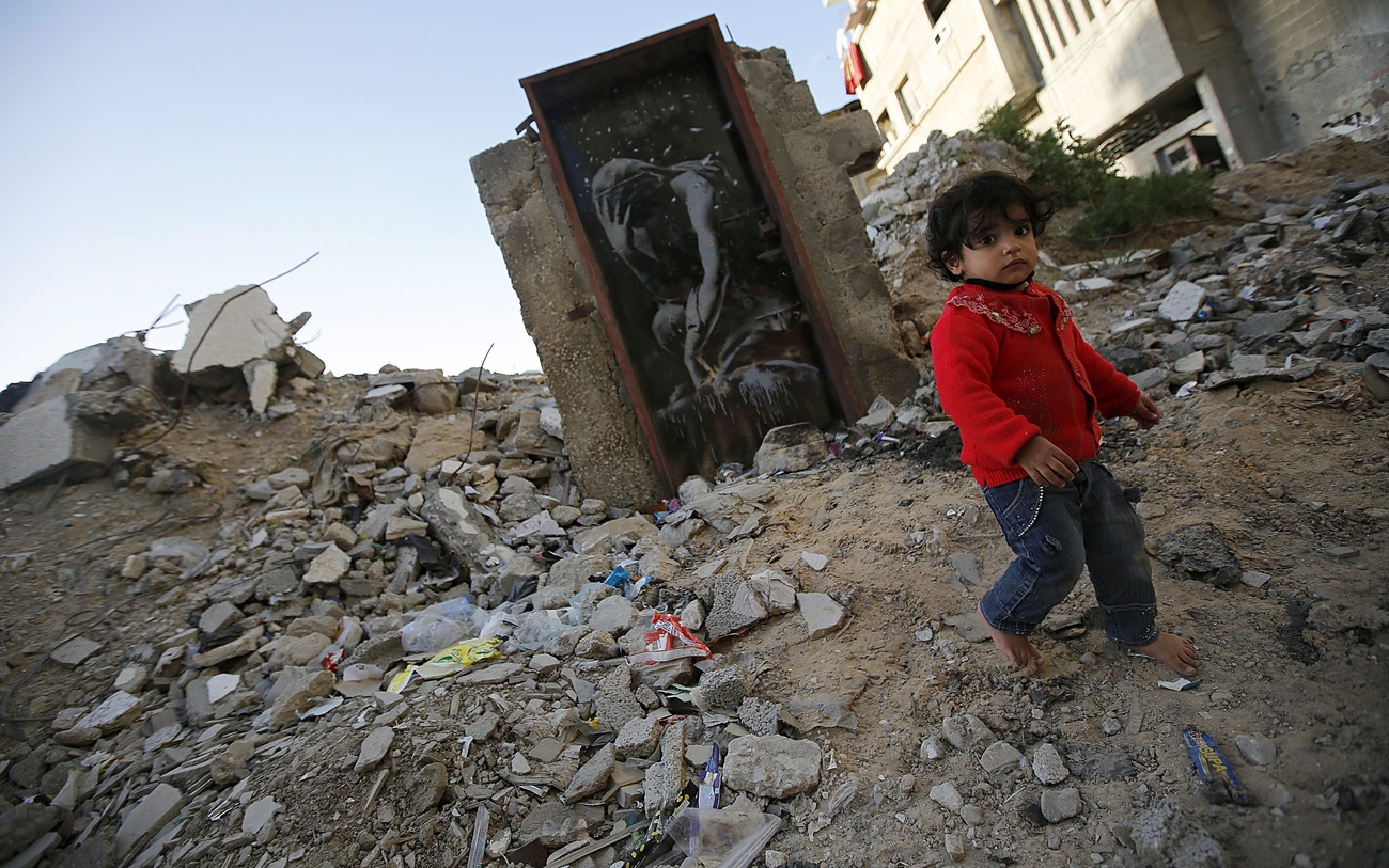 Mural of a crying figure wearing a head scarf on a house destroyed during the 2014 conflict between Israel and Hamas