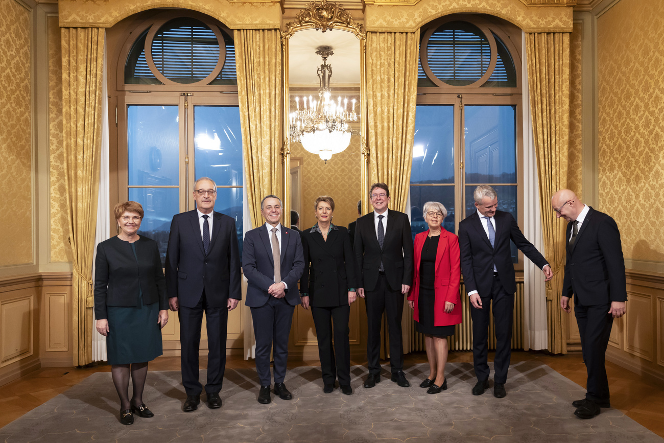 Foto des Gesamtbundesrates in einem opulenten Saal des Bundeshauses.