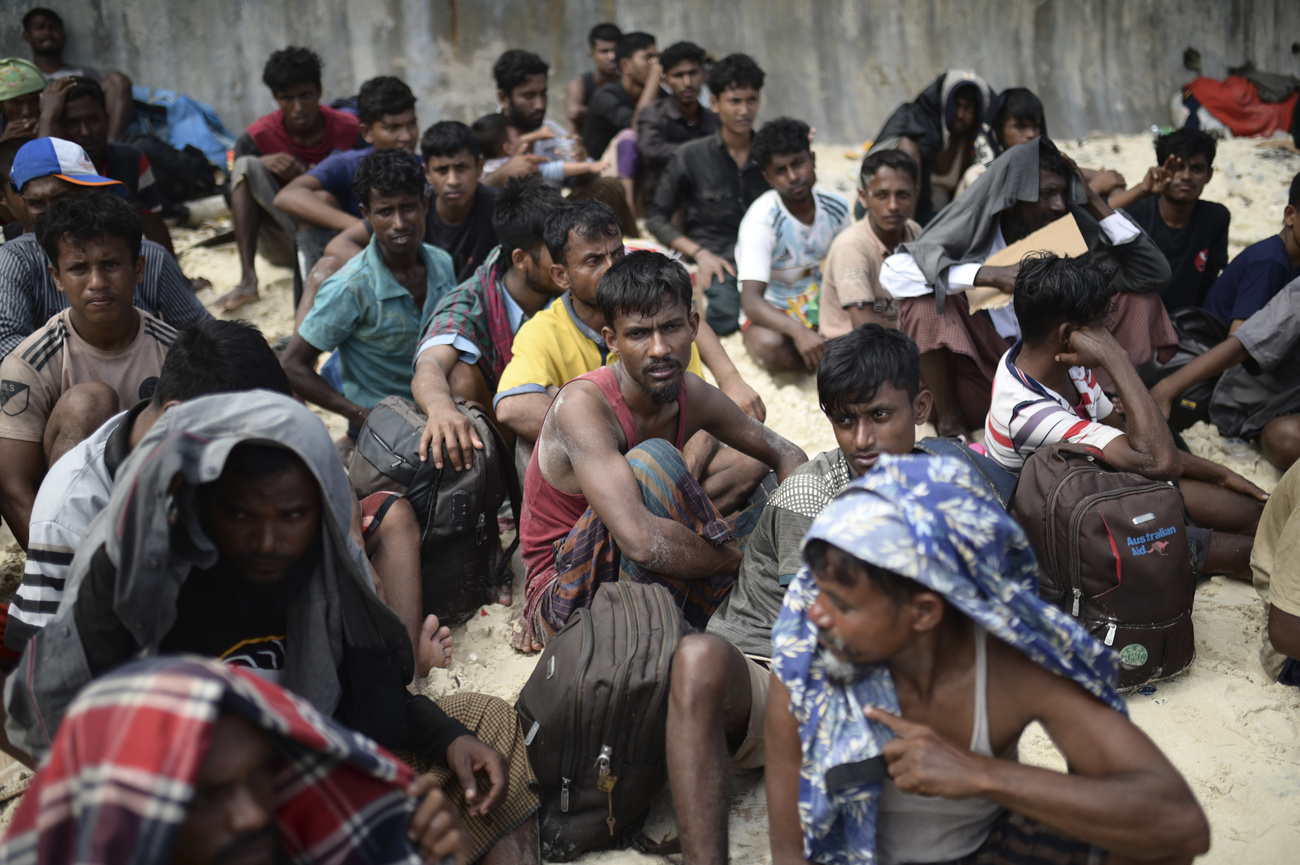 Ethnic Rohingya men sit on a beach after they landed in Sabang, Aceh province, Indonesia, Wednesday, Nov. 22, 2023.