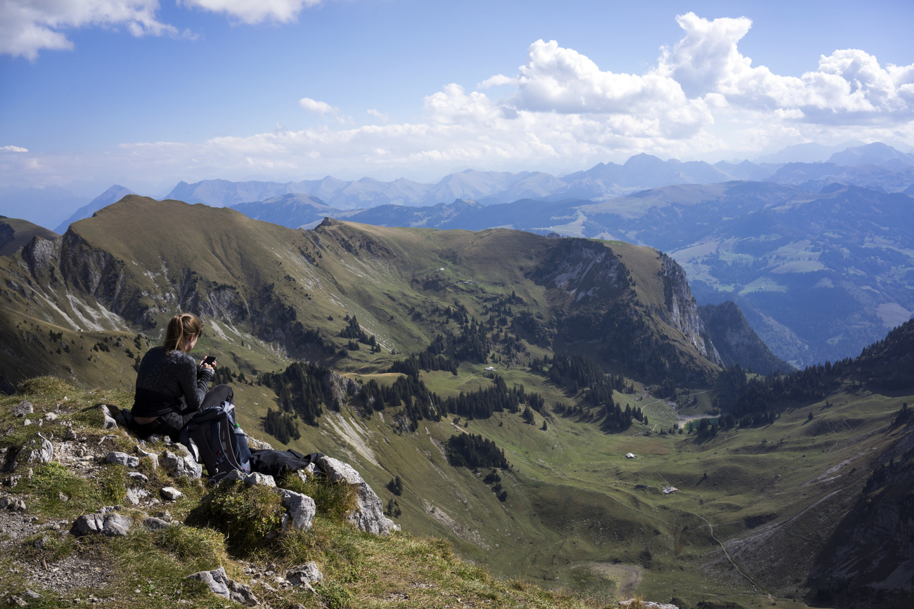 Una ragazza consulta il telefonino sul Kaiseregg (2185 m) sulle alpi friburghesi.