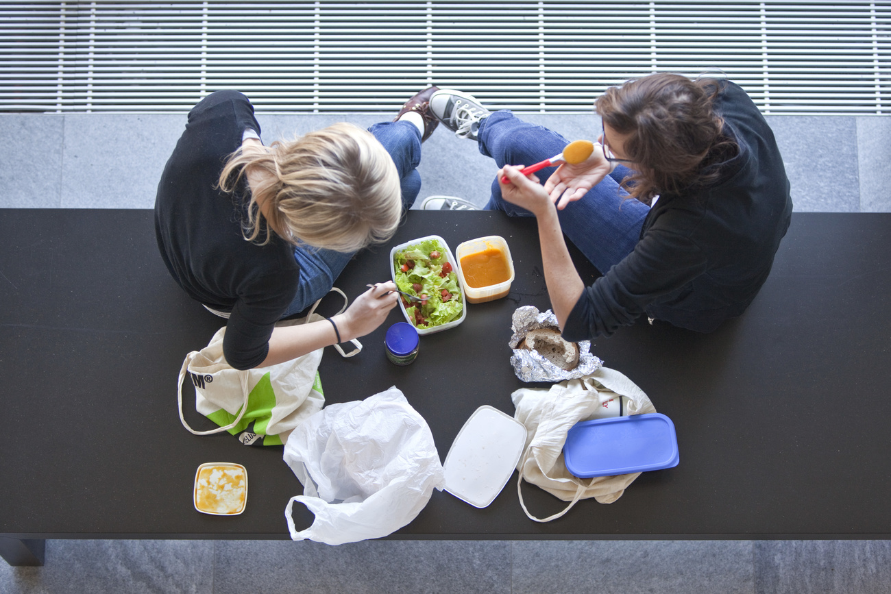 due giovani fotografati dall alto mangiano cibo da contenitori