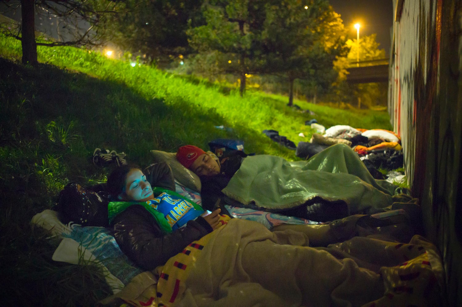 Gente durmiendo al raso junto a un puente