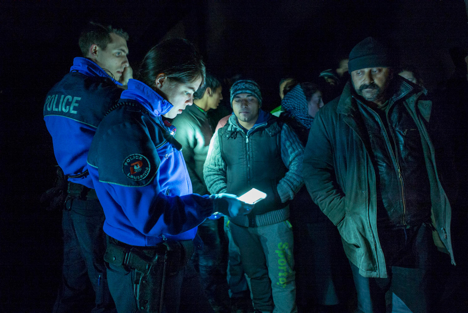 Poliziotti controllano un gruppo di persone di notte