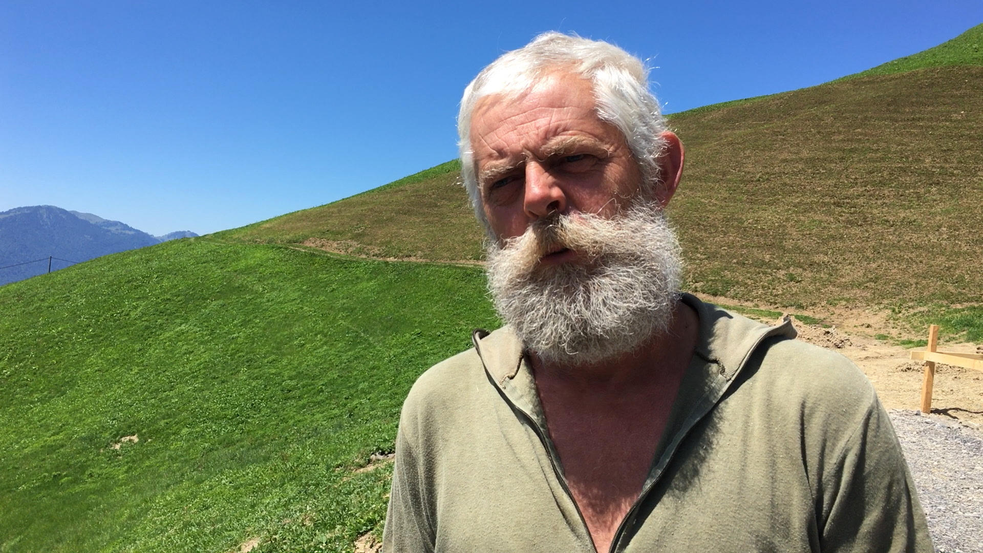 Ein älterer Mann vor grünen Hügeln