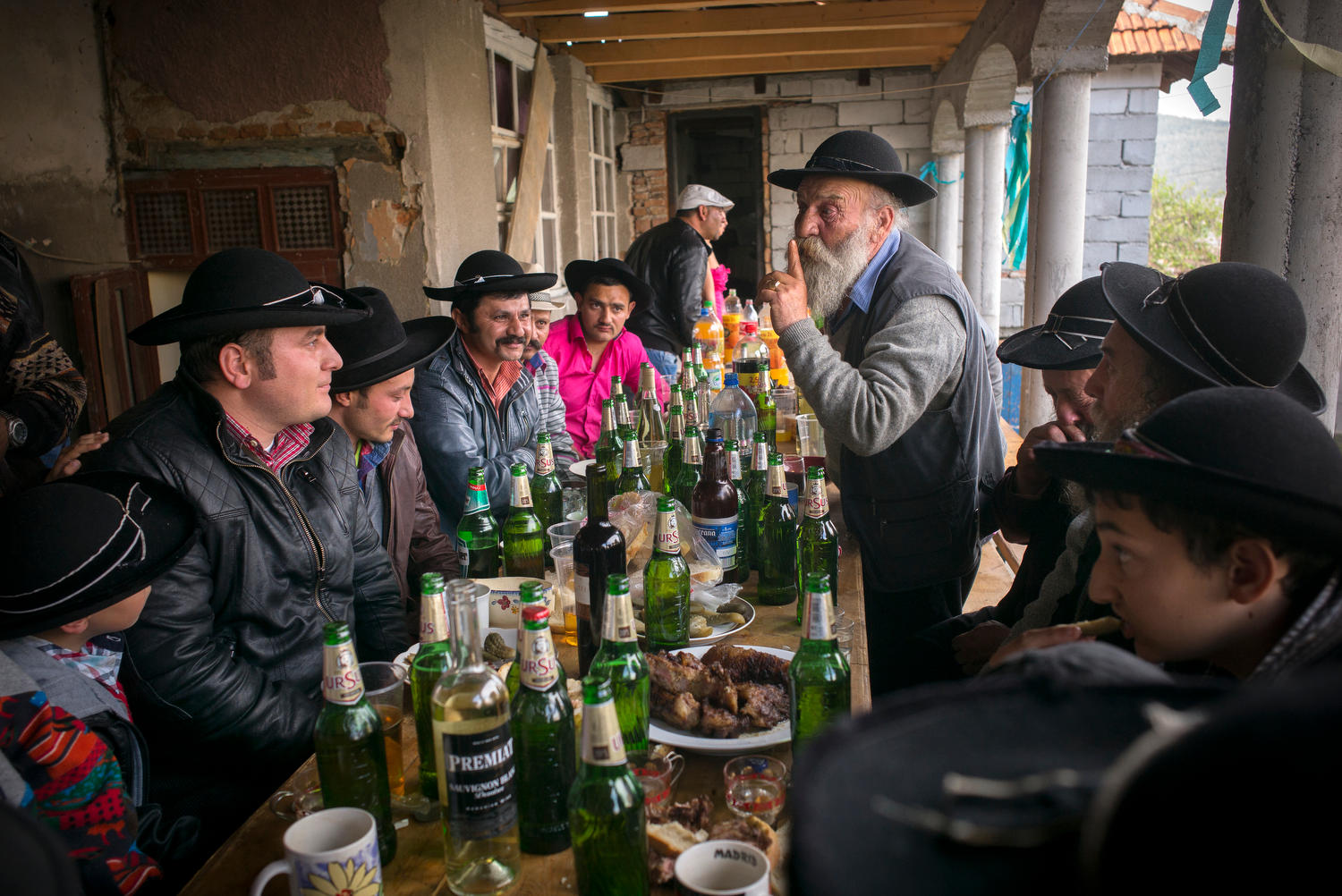 Männer sitzen während eines Festes an einem Tisch und essen und trinken.
