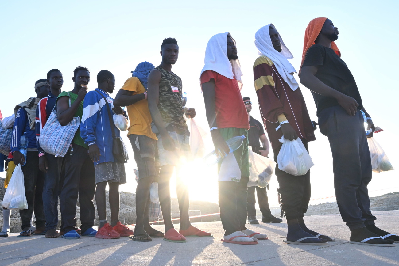 Migranti in fila dopo lo sbarco in Italia.