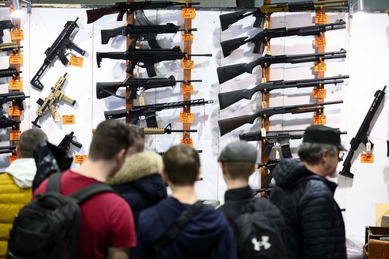 Visiteurs devant des fusils à la Bourse aux Armes