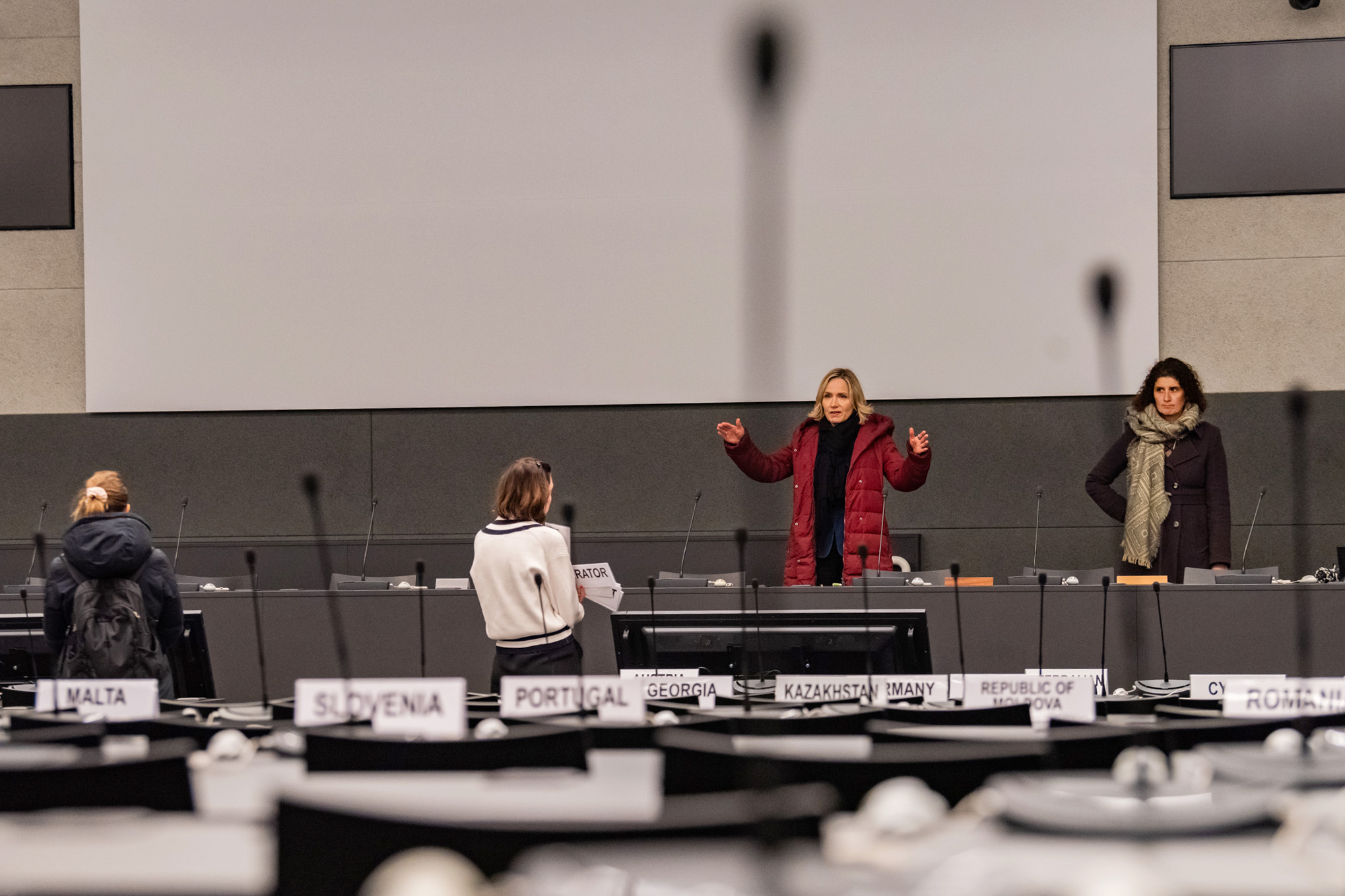 personnes en manteau dans une salle de conférence