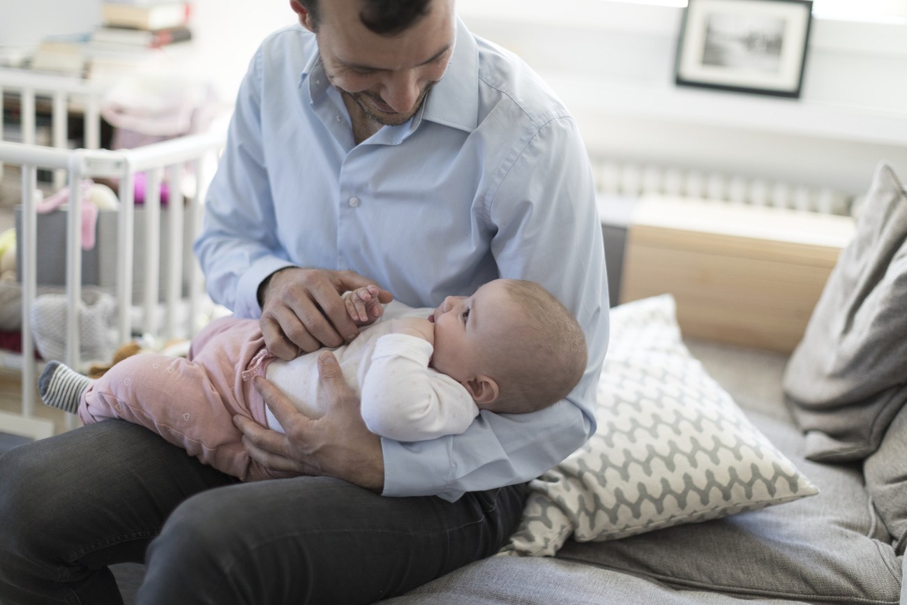un père tient son bébé dans les bras
