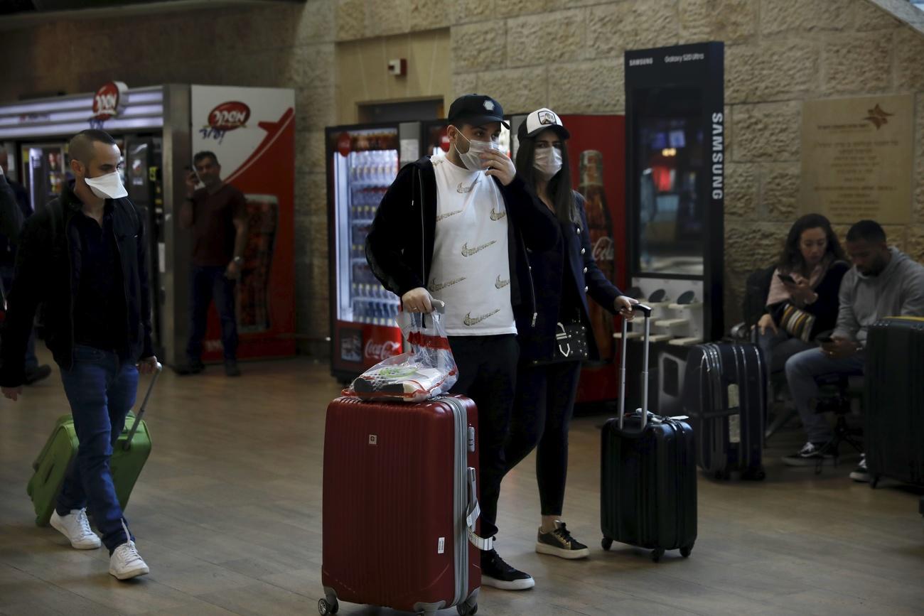 Passagiere mit Schutzmasken auf dem Flughafen Tel Aviv, Israel.