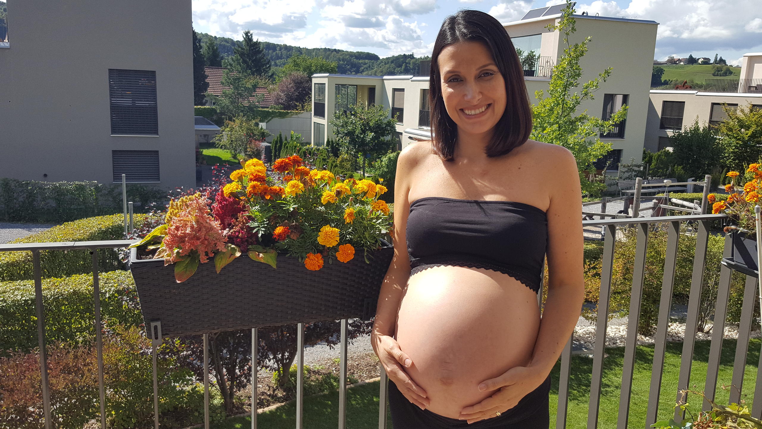 Uma mulher grávida na varanda de um prédio moderno