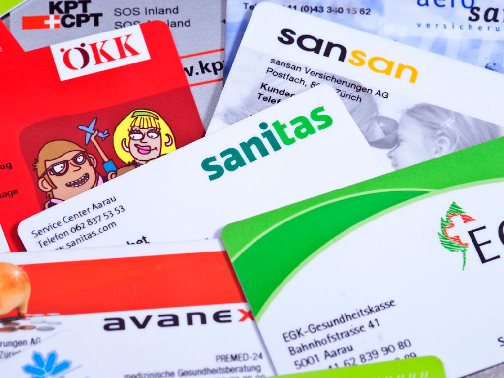 Verschiedene Krankenkassen-Karten liegen übereinander.