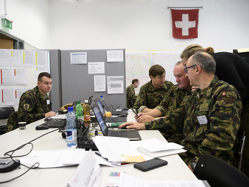 Des hommes en tenue camouflée assis autour d une table
