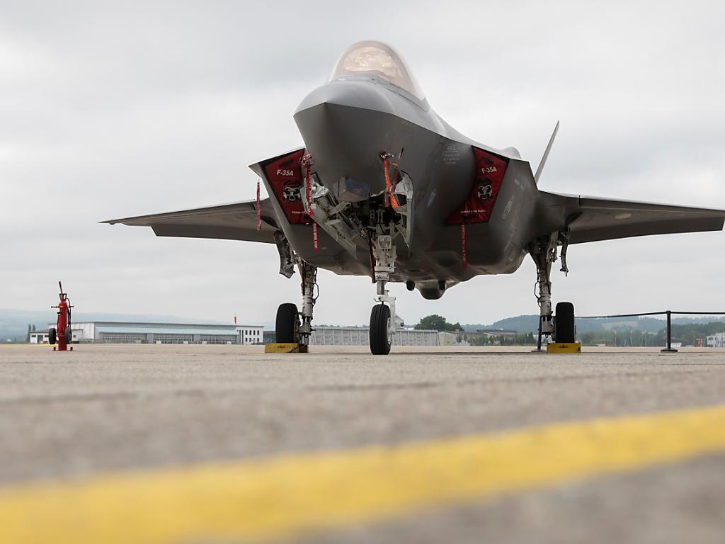 Ein Kampfjet steht auf einer Piste eines Flughafens.