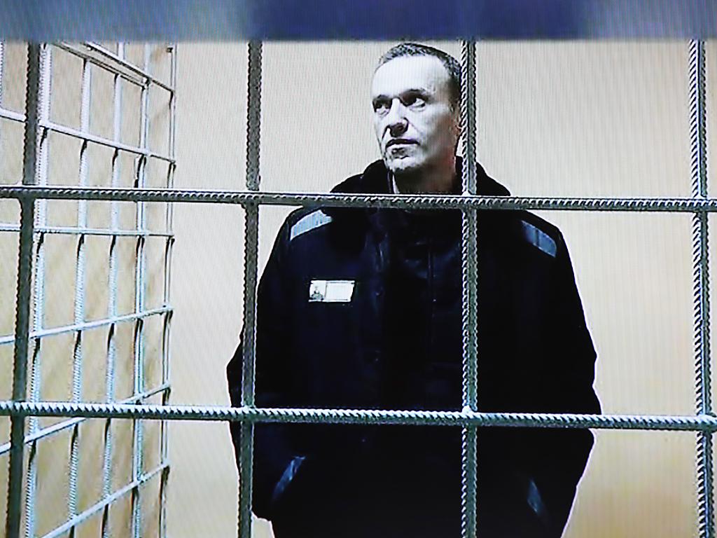 Alexej Nawalny in warmer Jacke hinter Gefängnisgitter