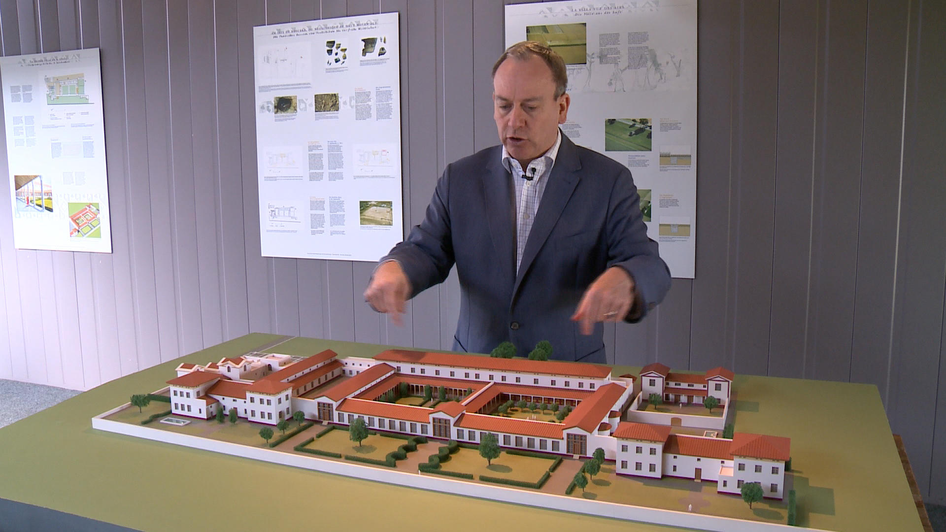 Homme présentant la maquette d une villa romaine.