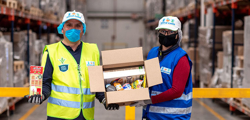 Dos personas con mascarillas y cajas de medicamentos