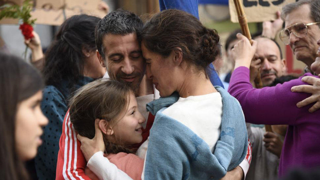 Se abrazan una pareja y su hija