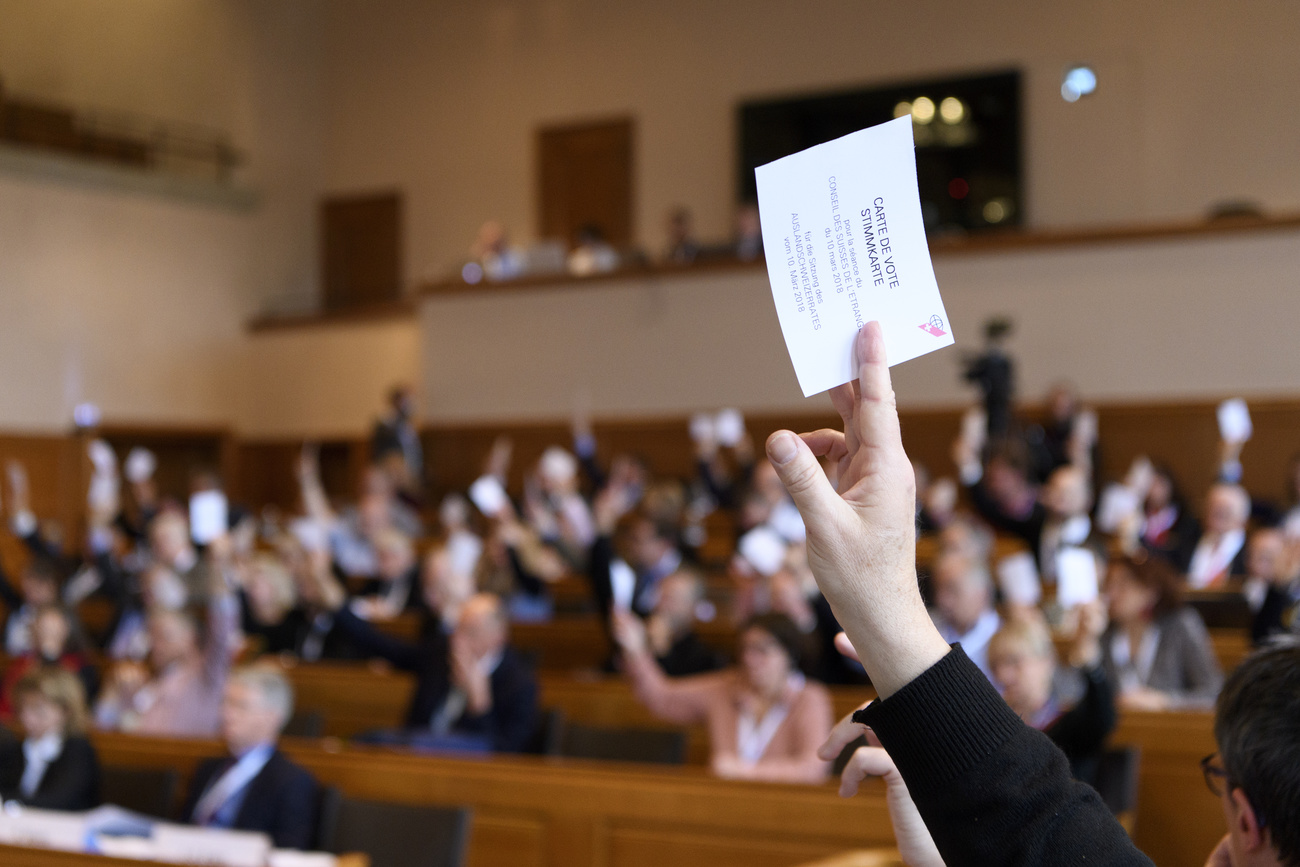 gente che vota alzando la mano con un foglietto
