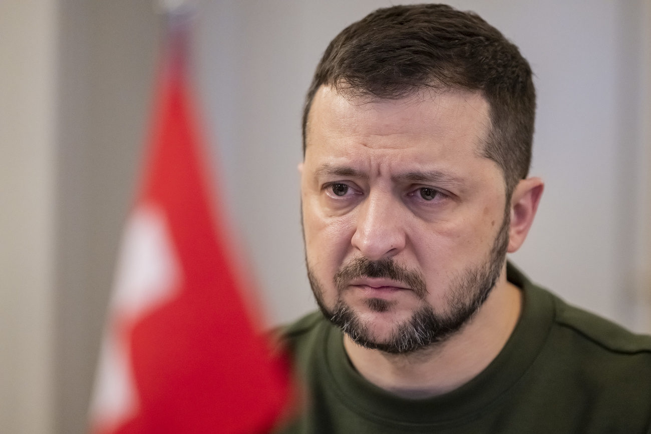 Ukrainian President Volodymyr Zelensky stands next to a Swiss flag.