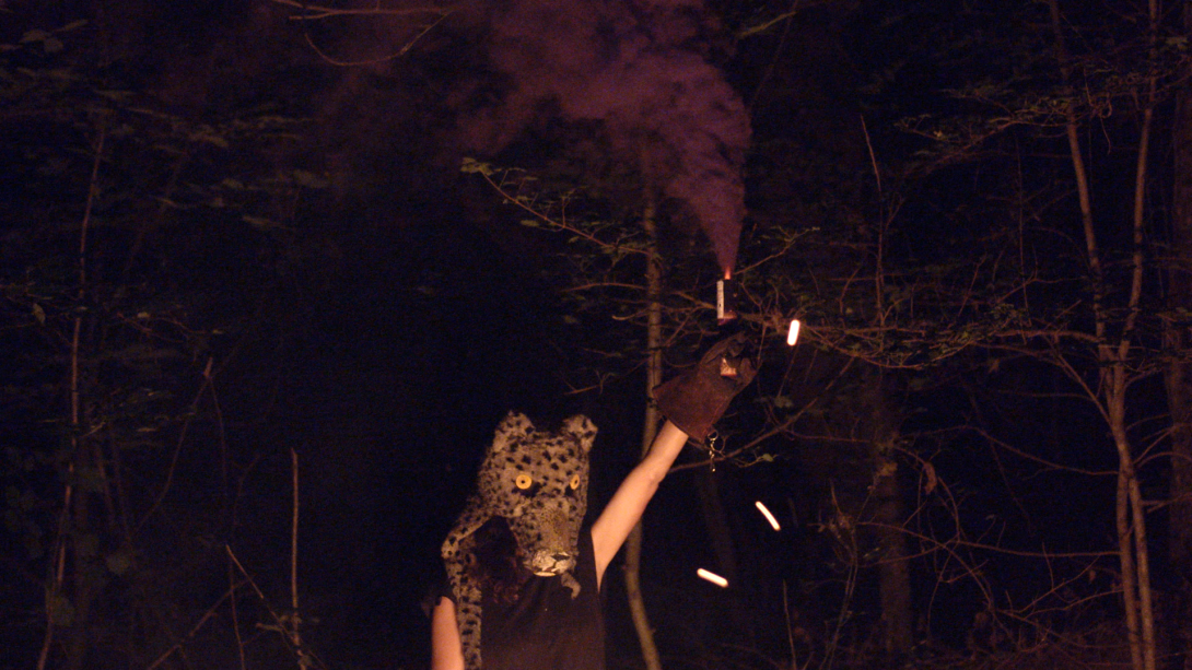 Woman with mask in a night ceremony in the woods