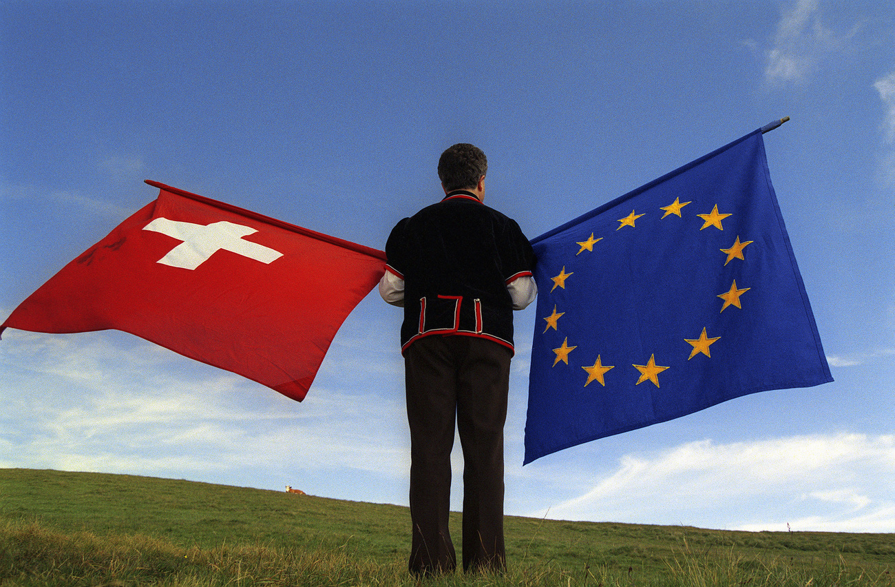 ein Fahnenschwinger mit einer Schweizer und einer EU-Flagge